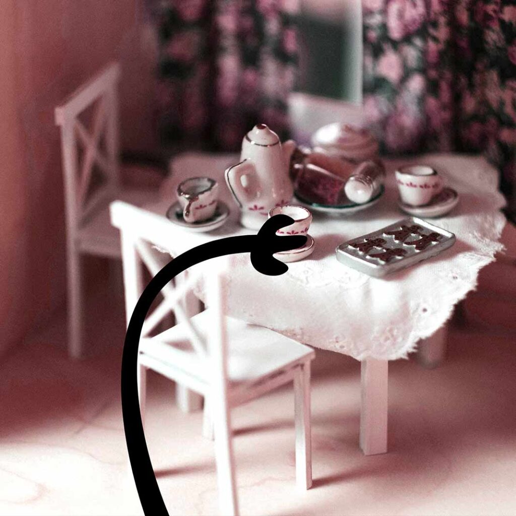 A table is set with a tea set and cookies. A black cartoon hand reaches for a teacup.